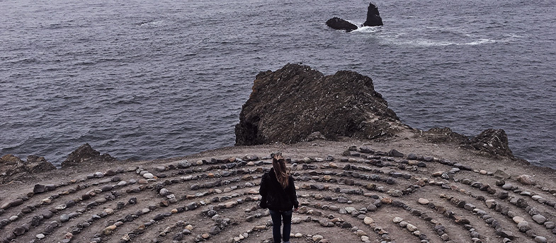 Woman standing by a cliff at the beach